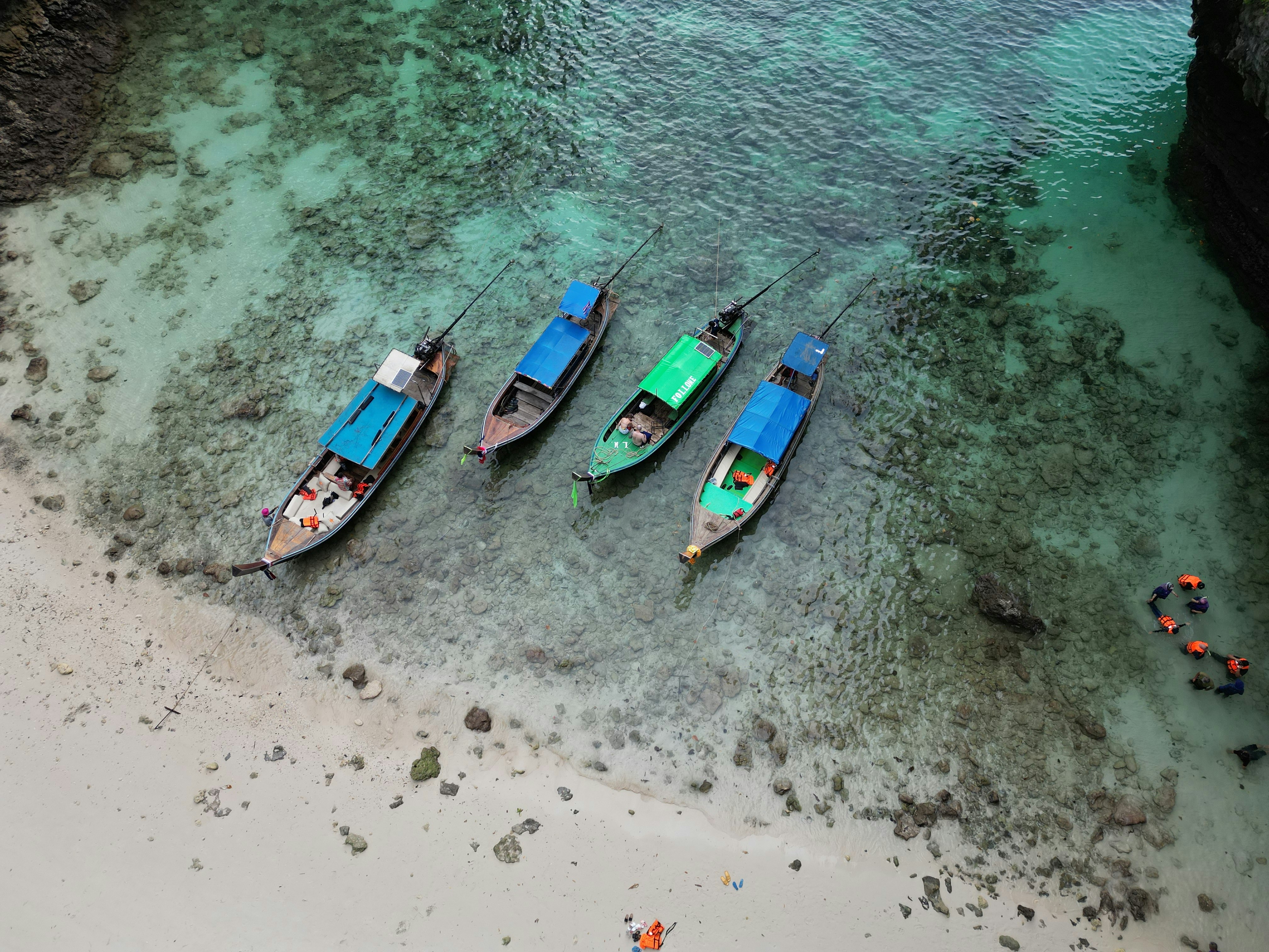 a group of three boats sitting on top of a beach