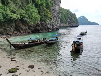 Traditional Moken boats anchored near the shore, reflecting the culture of the island’s sea nomads.