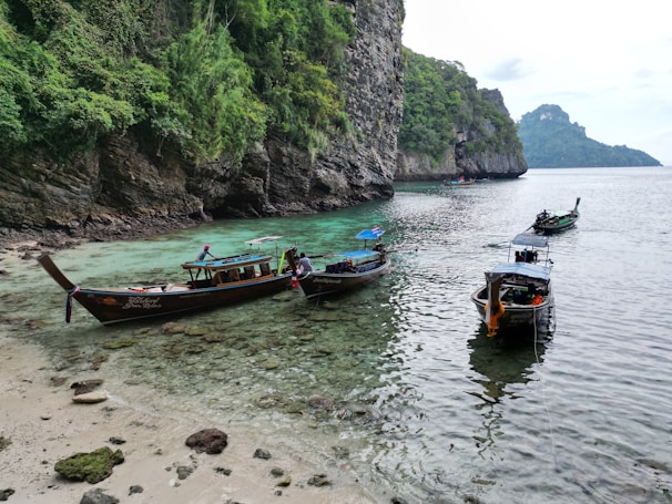 Traditional Moken boats anchored near the shore, reflecting the culture of the island’s sea nomads.