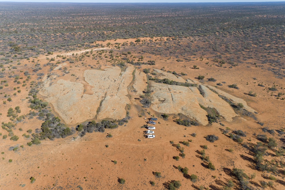 an aerial view of a dirt field with a truck in the middle of it