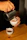 Close-up of hands pouring coffee mate into a steaming cup of coffee