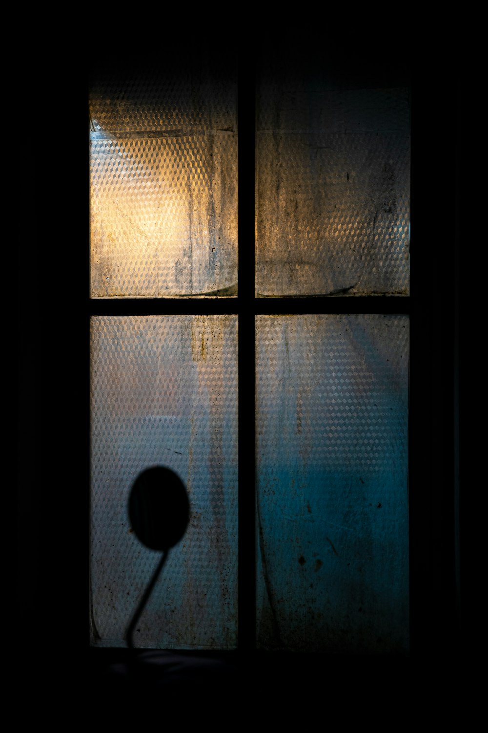 a shadow of a street light on a window