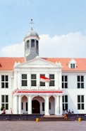 a large white building with a red and white flag