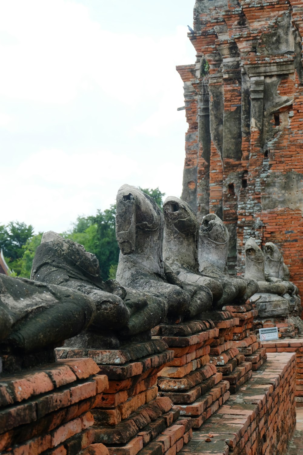 a group of statues sitting on top of a brick wall