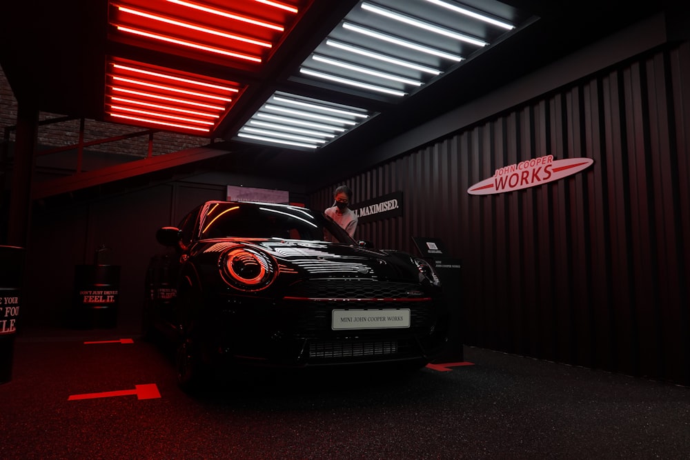 a man standing next to a car in a garage