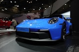 a blue sports car on display at a car show
