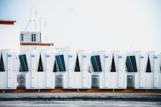 a row of portable air conditioners sitting on top of a roof