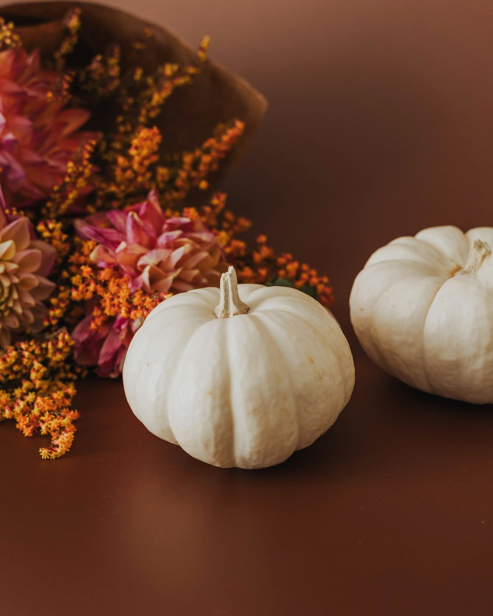 a couple of white pumpkins sitting on top of a table