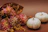 A close-up of a vibrant autumn-themed bouquet featuring warm orange and red flowers.