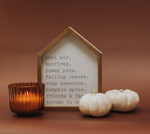 a candle and some white pumpkins on a table