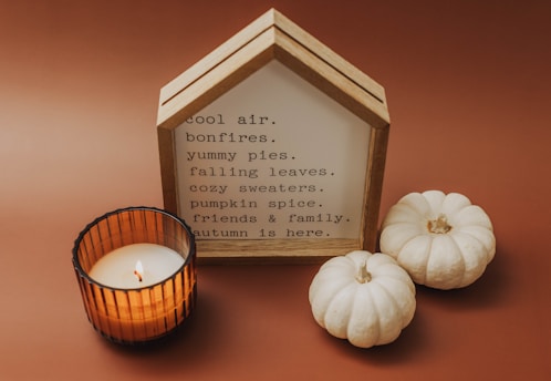 a candle and some pumpkins on a table