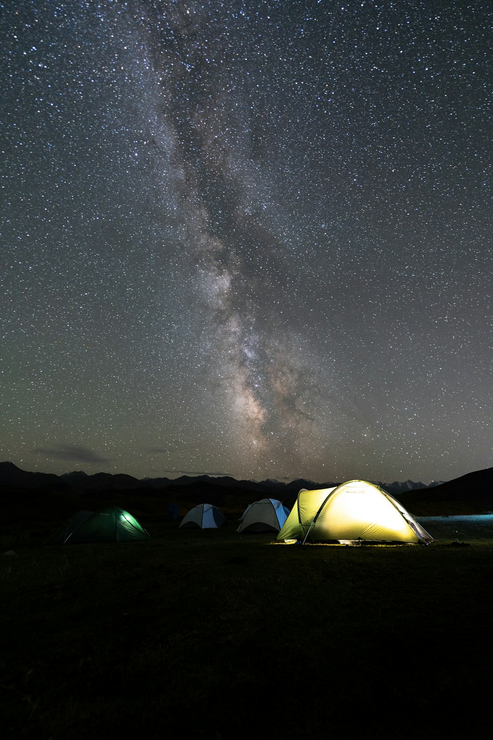 a group of tents sitting under a night sky filled with stars