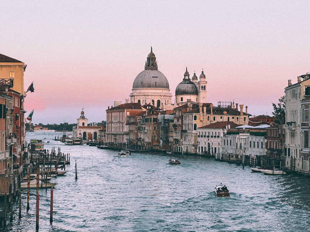 a boat traveling down a river next to tall buildings