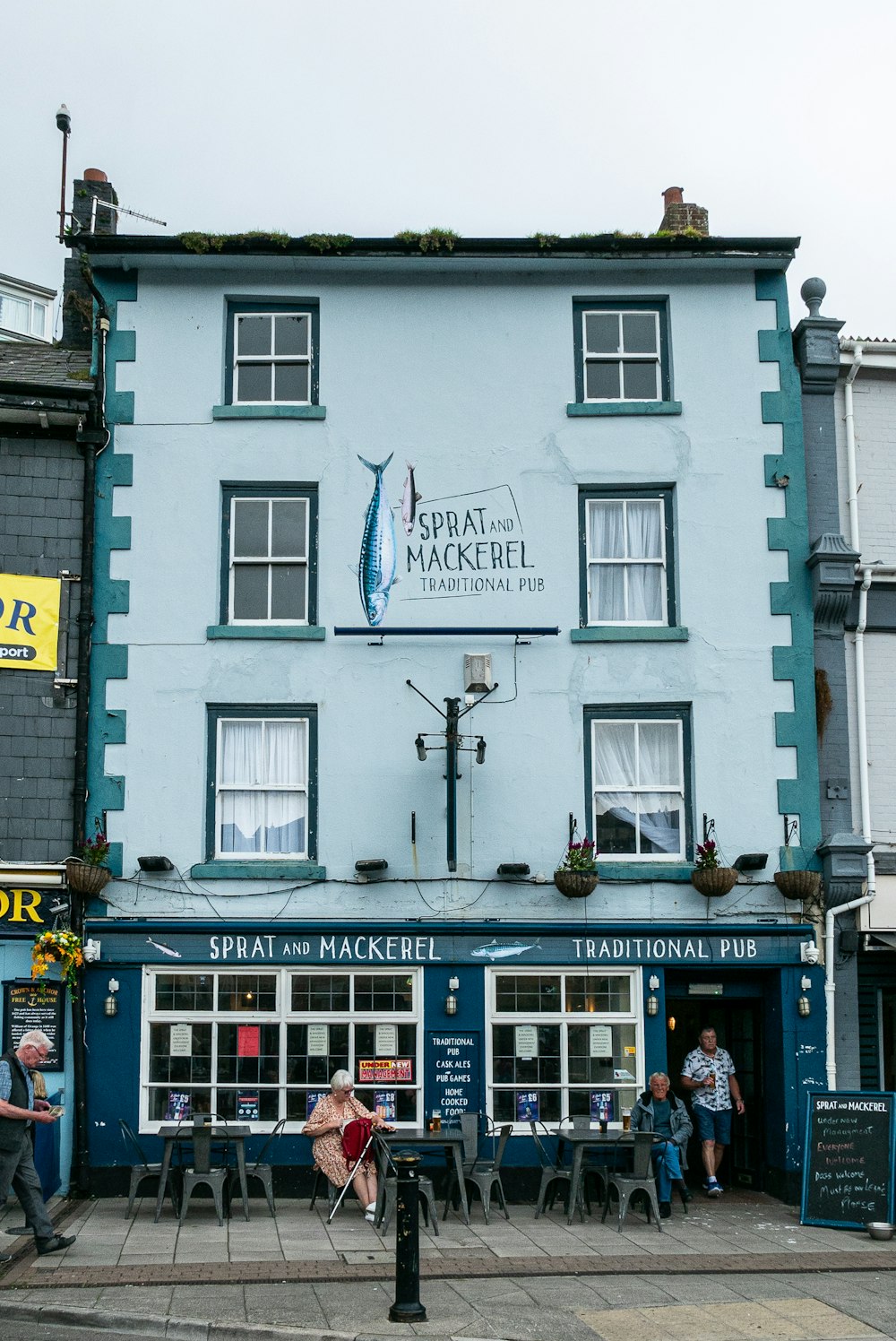 a large blue building with people sitting outside of it