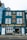 A vibrant blue building with white-framed windows featuring a café bar and bistro named La Petite Maison. The façade displays yellow text advertising breakfast, lunch, dinner, and all-day food on offer. A decorative clock is mounted above, and the street outside is paved.