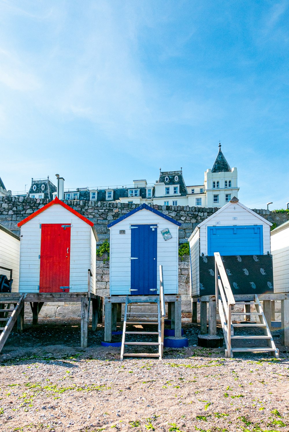 a row of beach huts sitting on top of a sandy beach