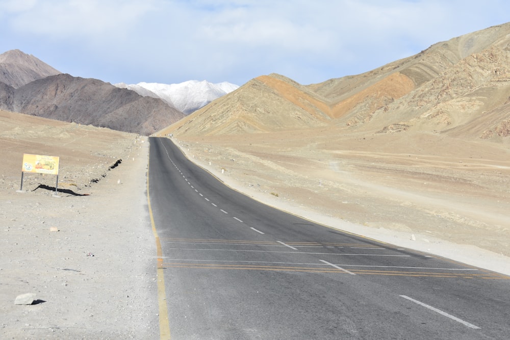 Un camino en medio de un desierto con montañas al fondo