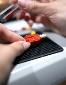 Close-up of hands assembling a creative toy model.