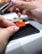 Hands assembling a miniature furniture piece in a bright, modern workspace.