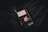 A copy of David Copperfield by Charles Dickens lies on a dark, textured fabric surface. The book cover features an illustrated portrait of a young person, with a black, white, and red color scheme. A tassel bookmark protrudes from the top of the book, adding texture and dimension.