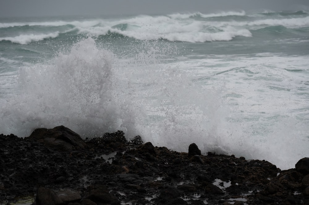 a wave crashing on a rocky shore