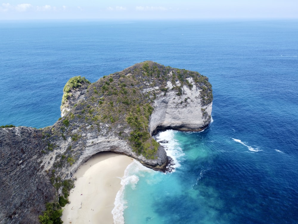 an aerial view of a beach with a rock outcropping