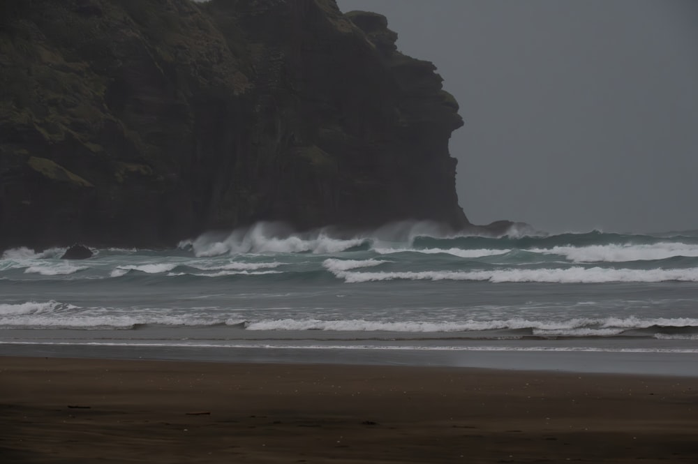 a person walking on a beach with a surfboard