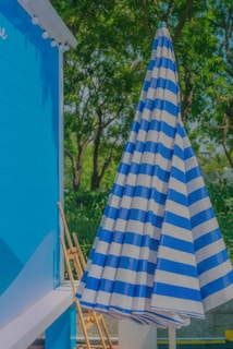 A compact navy blue umbrella folded neatly beside a matching carrying case.