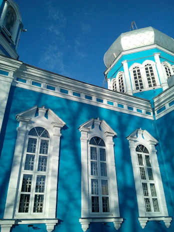A vibrant school building with blue and violet accents under a clear sky.