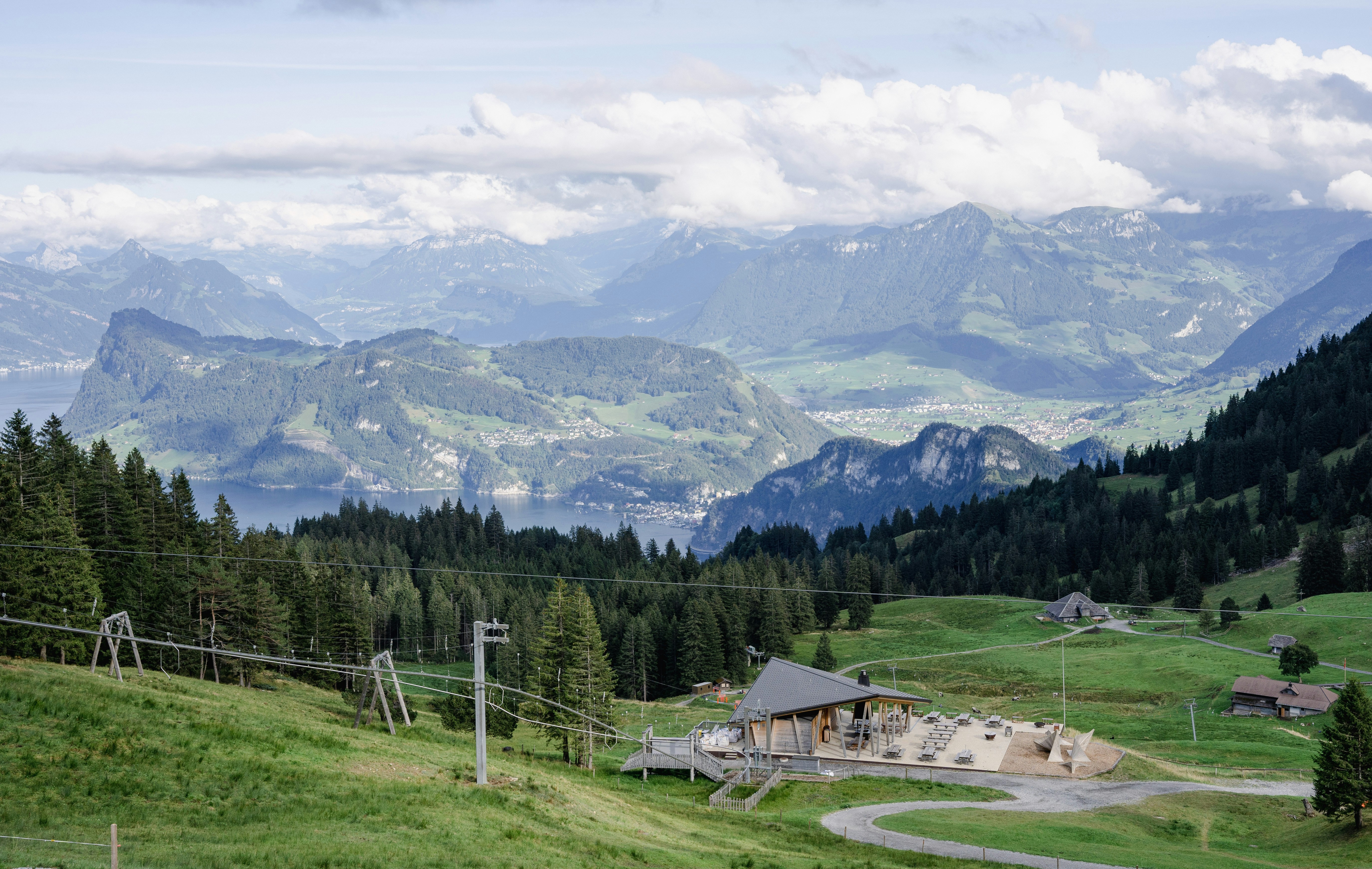a scenic view of a mountain range with a house in the foreground
