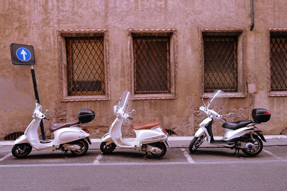 Tre scooter parcheggiati uno accanto all'altro davanti a un edificio