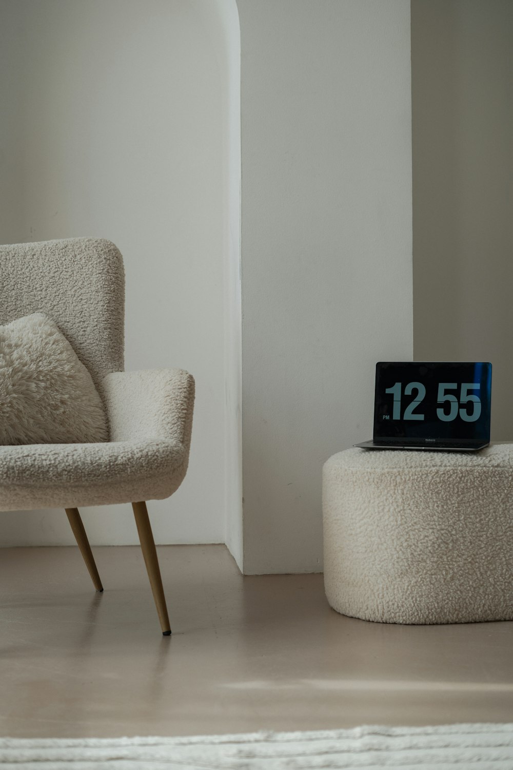 a chair and ottoman in a room with a clock