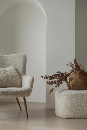 a chair and a vase with a plant in it