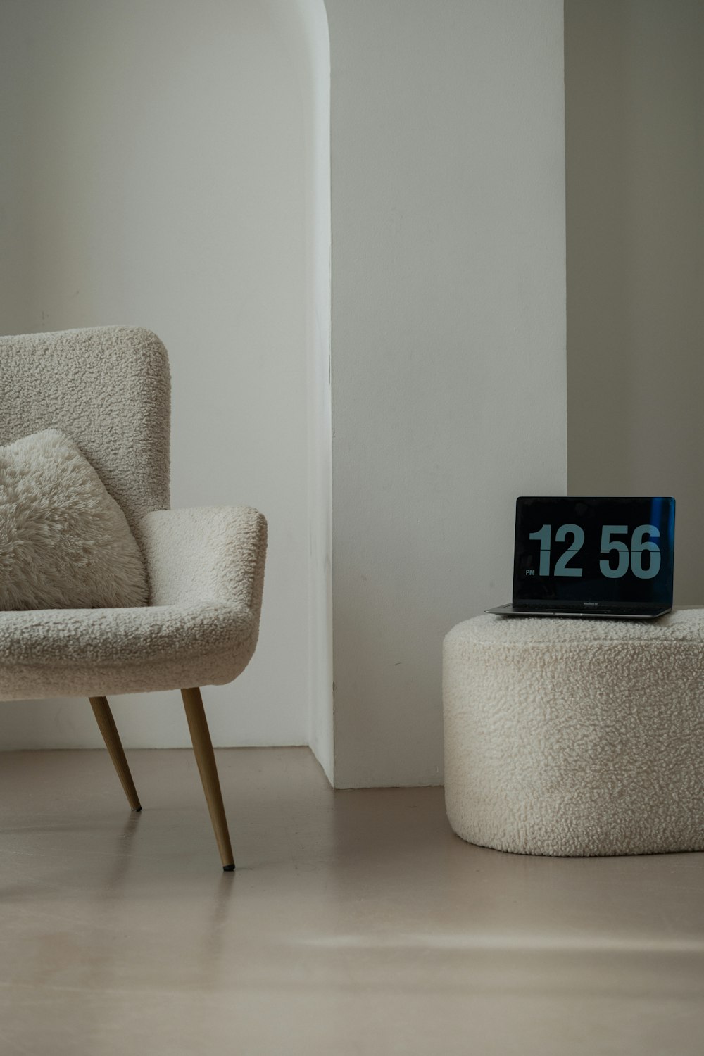 a chair and ottoman in a room with a clock