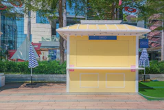a yellow kiosk with blue and white striped umbrellas