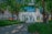 A panoramic view of a modern architectural structure surrounded by lush greenery.