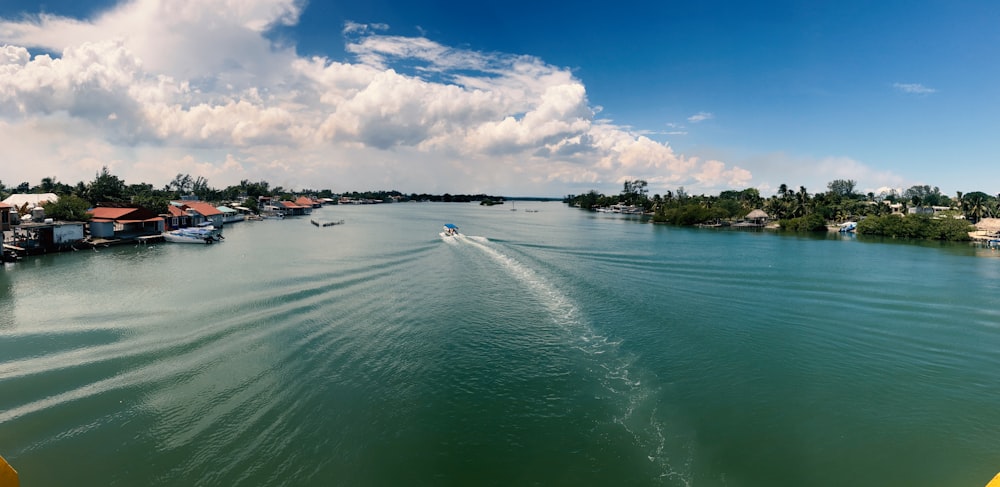 a boat traveling down a river next to houses