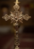 High-end artistic cross with detailed engravings against a soft, warm background.