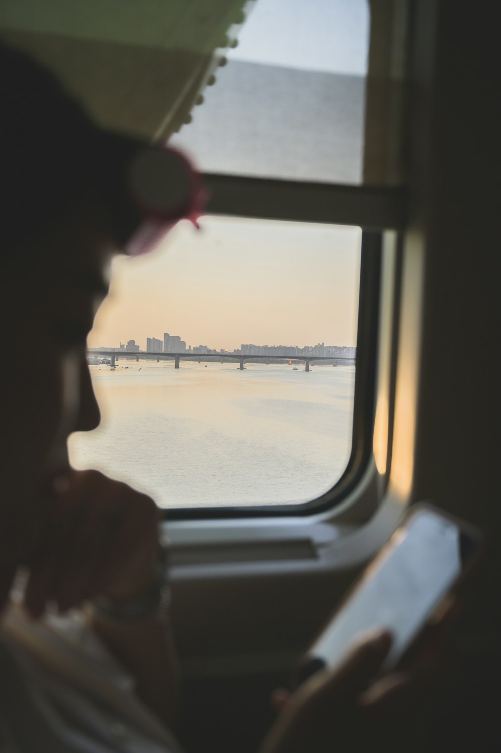 a person looking out a window at a body of water