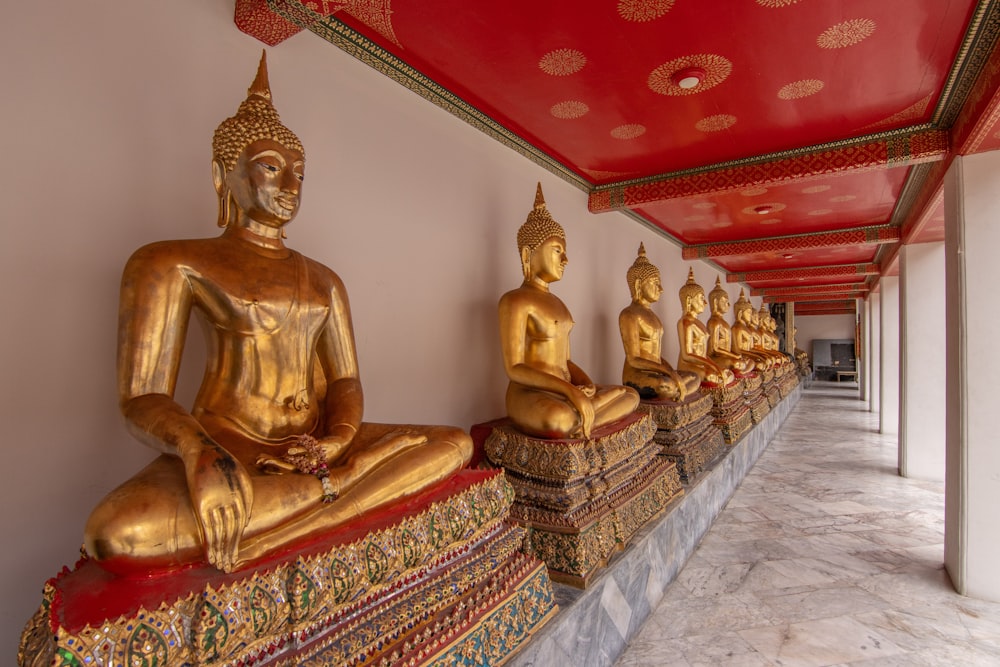 Una hilera de estatuas doradas de Buda sentadas una al lado de la otra