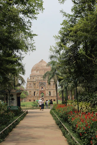 a walkway leading to a large building with a clock tower in the background