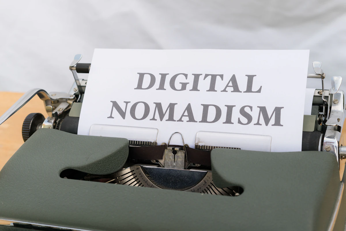 a close up of a typewriter with a paper that reads digital nomadism
