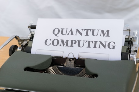 A green vintage typewriter holding a sheet of paper with the words 'Quantum Computing' typed in bold letters.