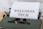 A vintage typewriter holds a sheet of paper with the words 'WELLNESS TECH' typed in large, bold letters. The typewriter is in a shade of olive green, with a focus on the metal and mechanical components. The paper is placed neatly in the roller, ready for typing more text.