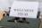 A vintage typewriter holds a sheet of paper with the words 'WELLNESS TECH' typed in large, bold letters. The typewriter is in a shade of olive green, with a focus on the metal and mechanical components. The paper is placed neatly in the roller, ready for typing more text.