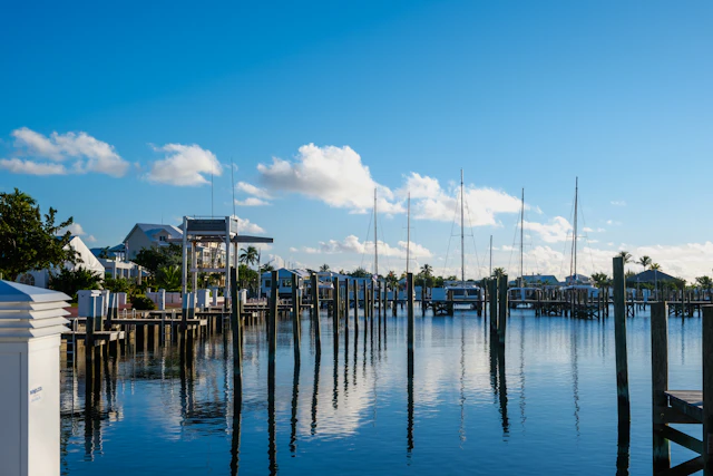 Calm marina in the Bahamas with moorings and masts reflected in still blue water under a bright sky