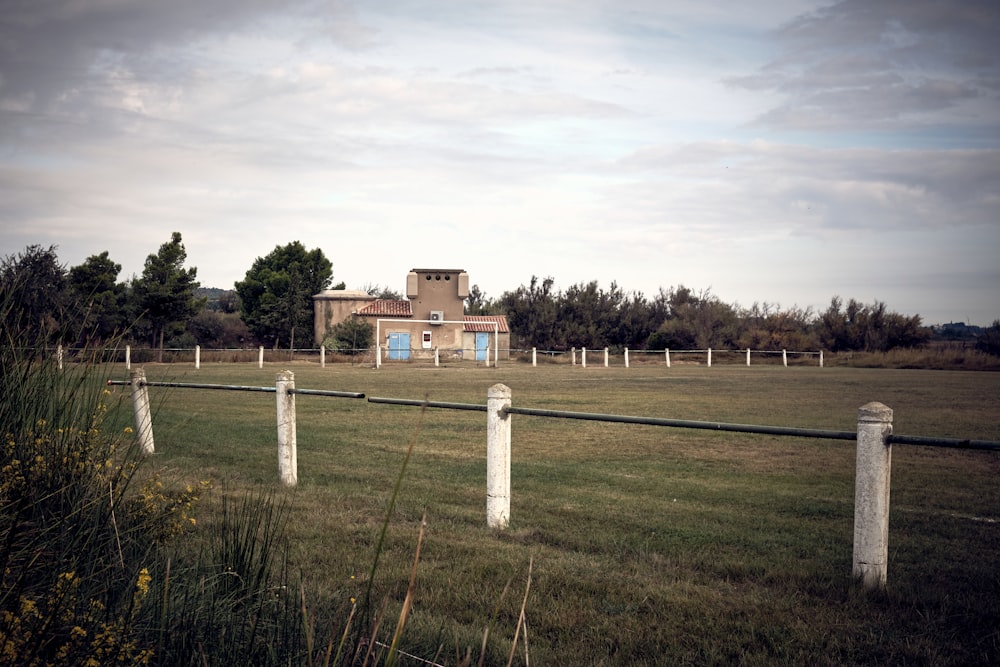 a large field with a house in the background