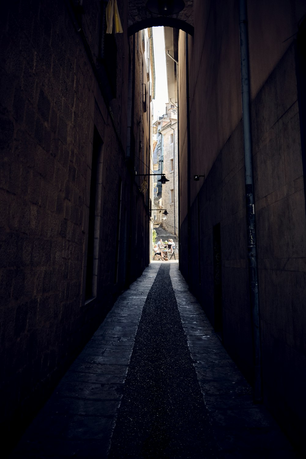 a narrow alley way with a clock on the wall