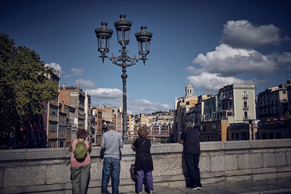 a group of people standing next to a street light