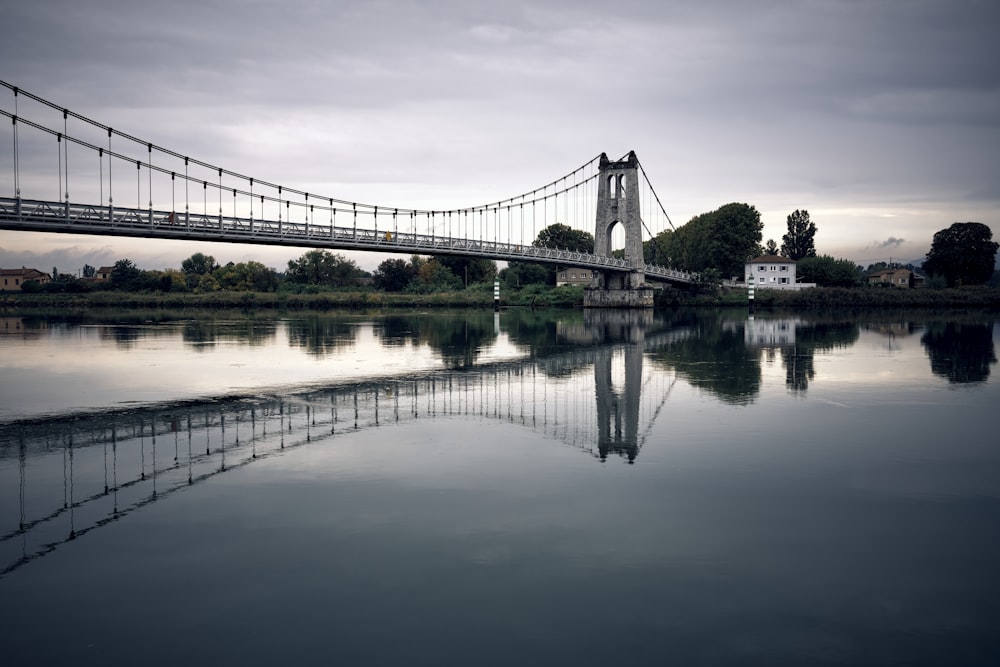 a bridge over a body of water under a cloudy sky